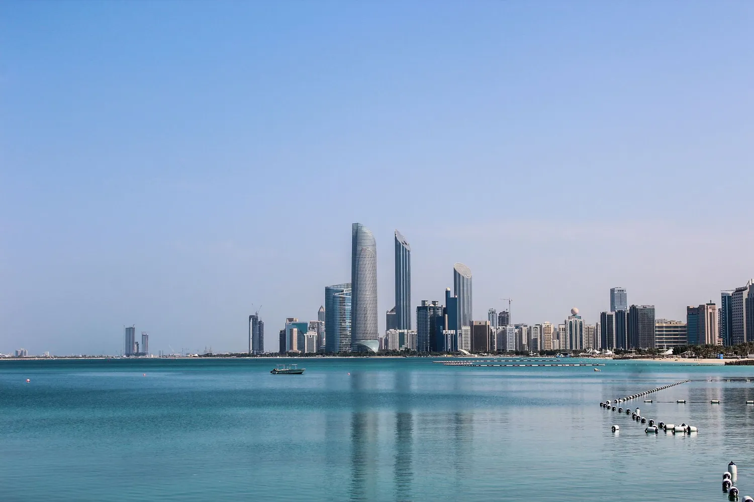 The Abu Dhabi skyline across calm water on a clear day