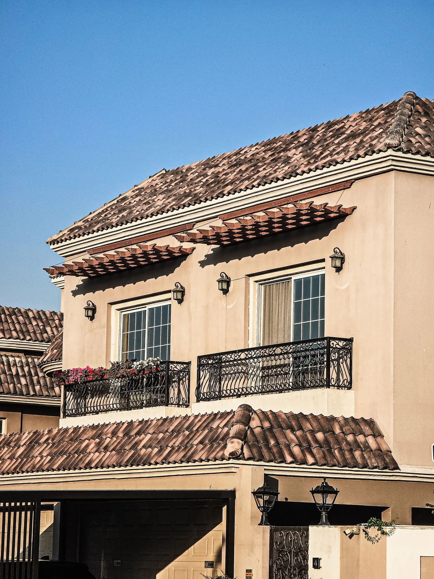 A two-storey townhouse facade with balconies under a clear sky